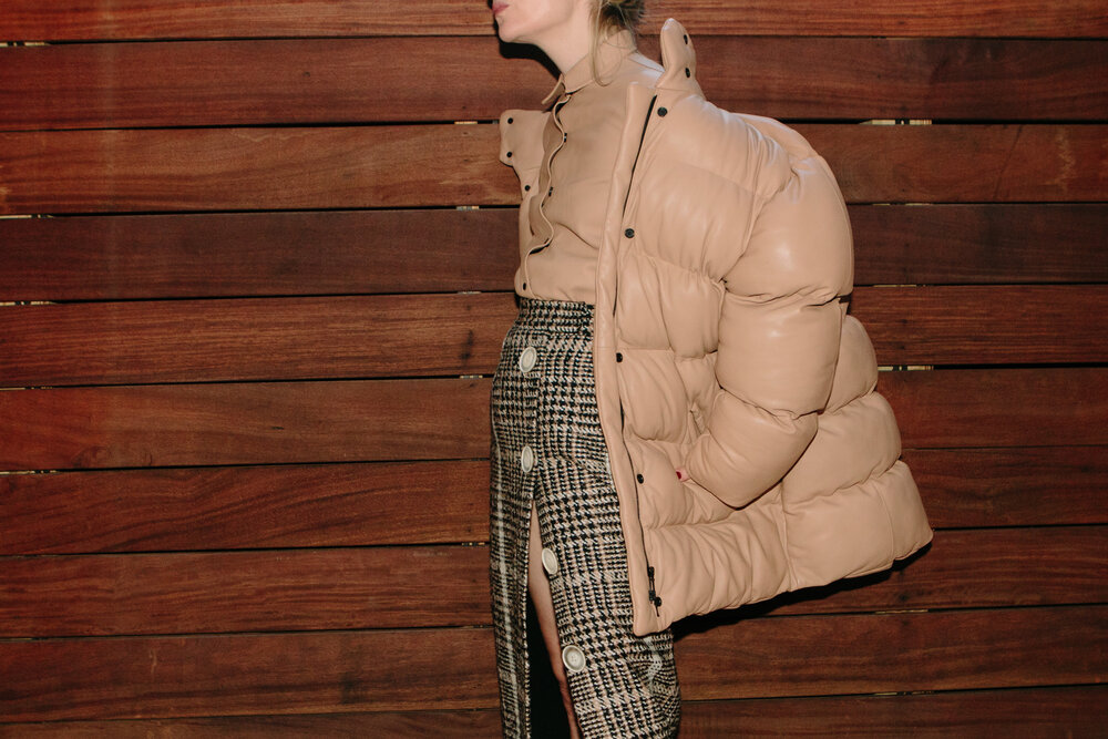 Julia wears a Carmen March leather puffer coat, skirt and shirt, and Manolo Blahnik heels.